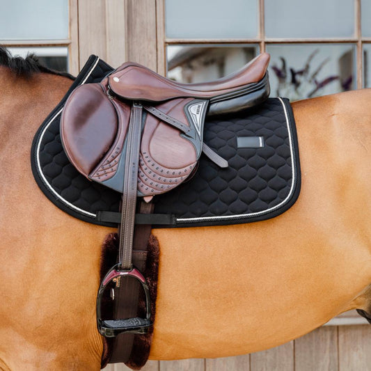Black saddlepad under a brown saddle on a bay horse