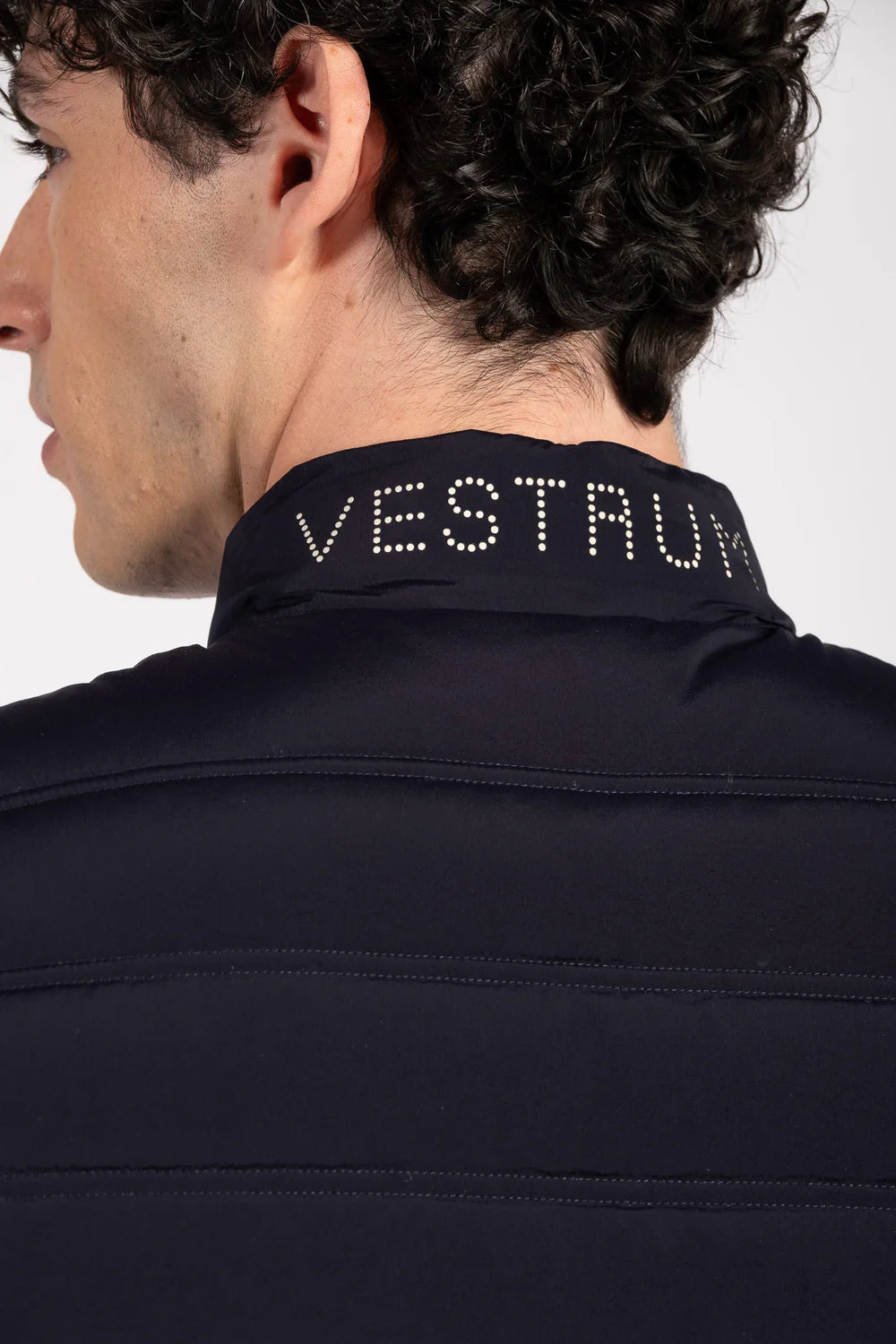 Navy jacket with 'VESTRUM' branding on a plain background
