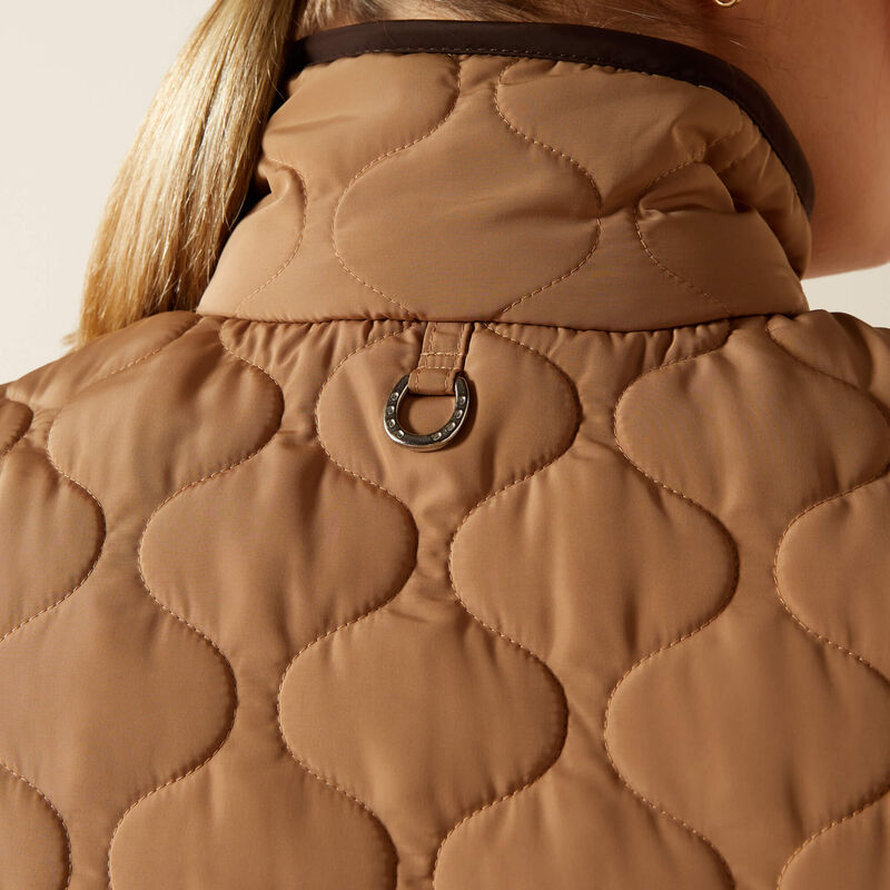 Detail of a beige quilted vest on a beige background