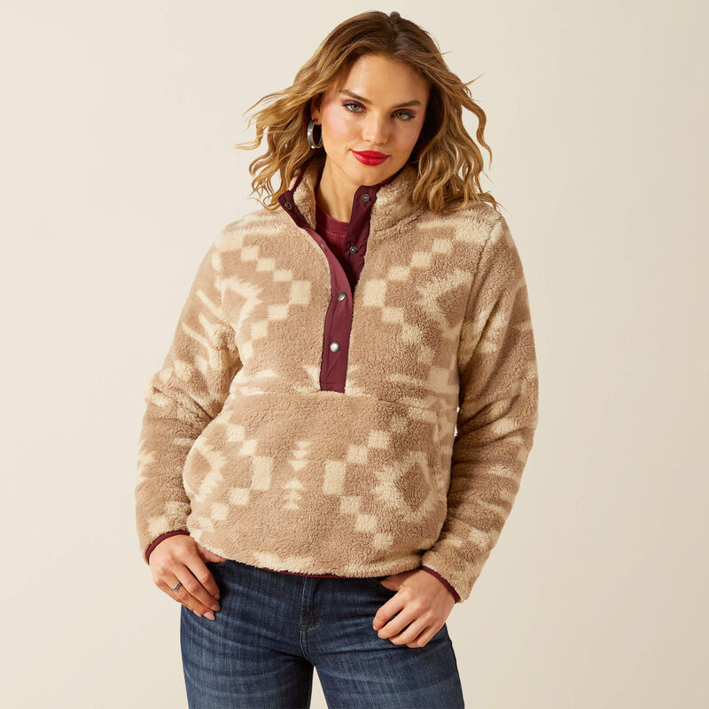 Woman wearing a patterned fleece pullover with a neutral background