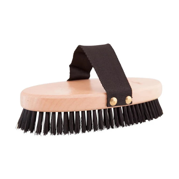 A horse grooming brush with a light natural wood handle, black bristles, and a black fabric strap secured by two brass rivets, shown on a plain white background.