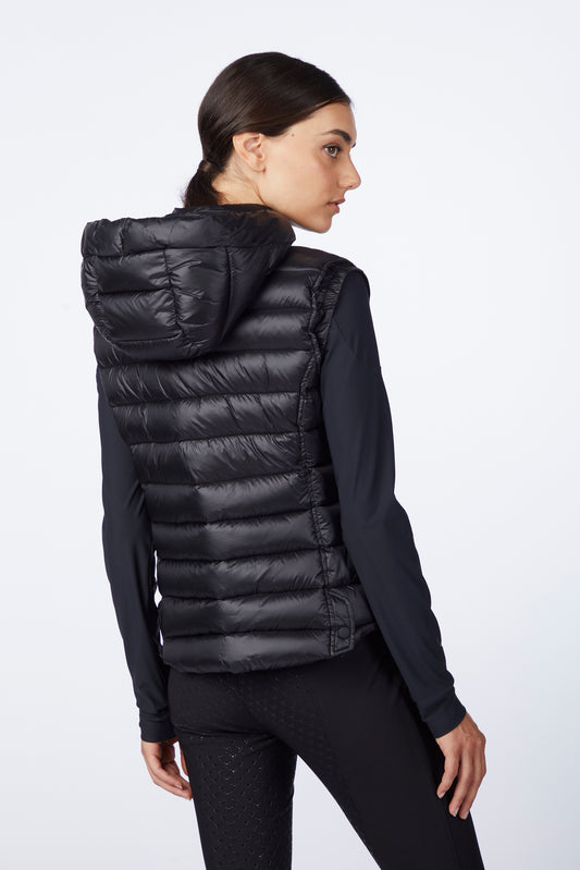 Woman wearing a black puffer vest on a white background