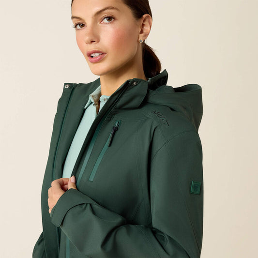 Woman wearing a green jacket with a beige background