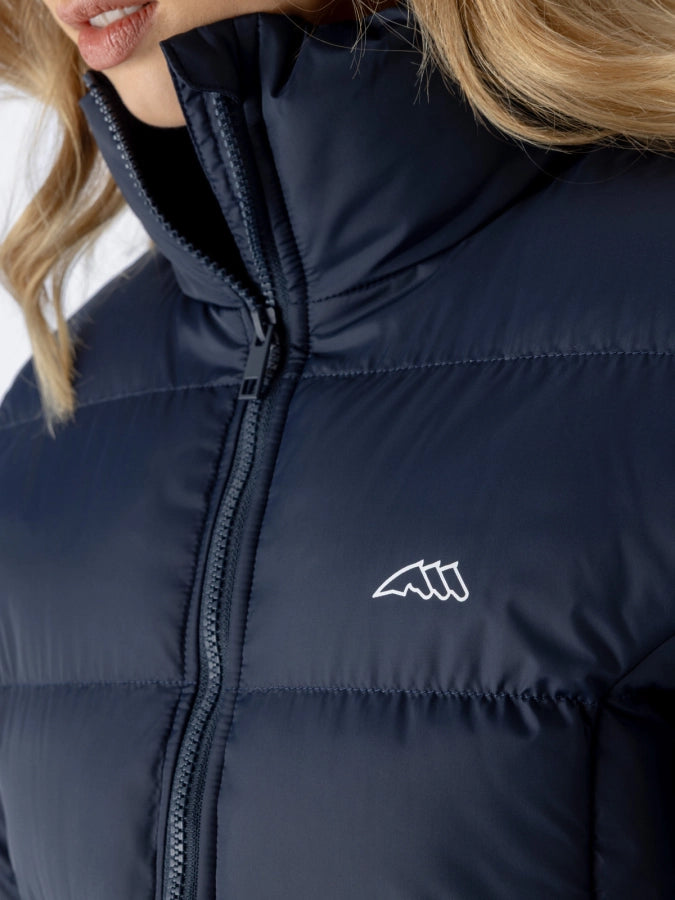 Navy puffer jacket with a brand logo on a blurred background