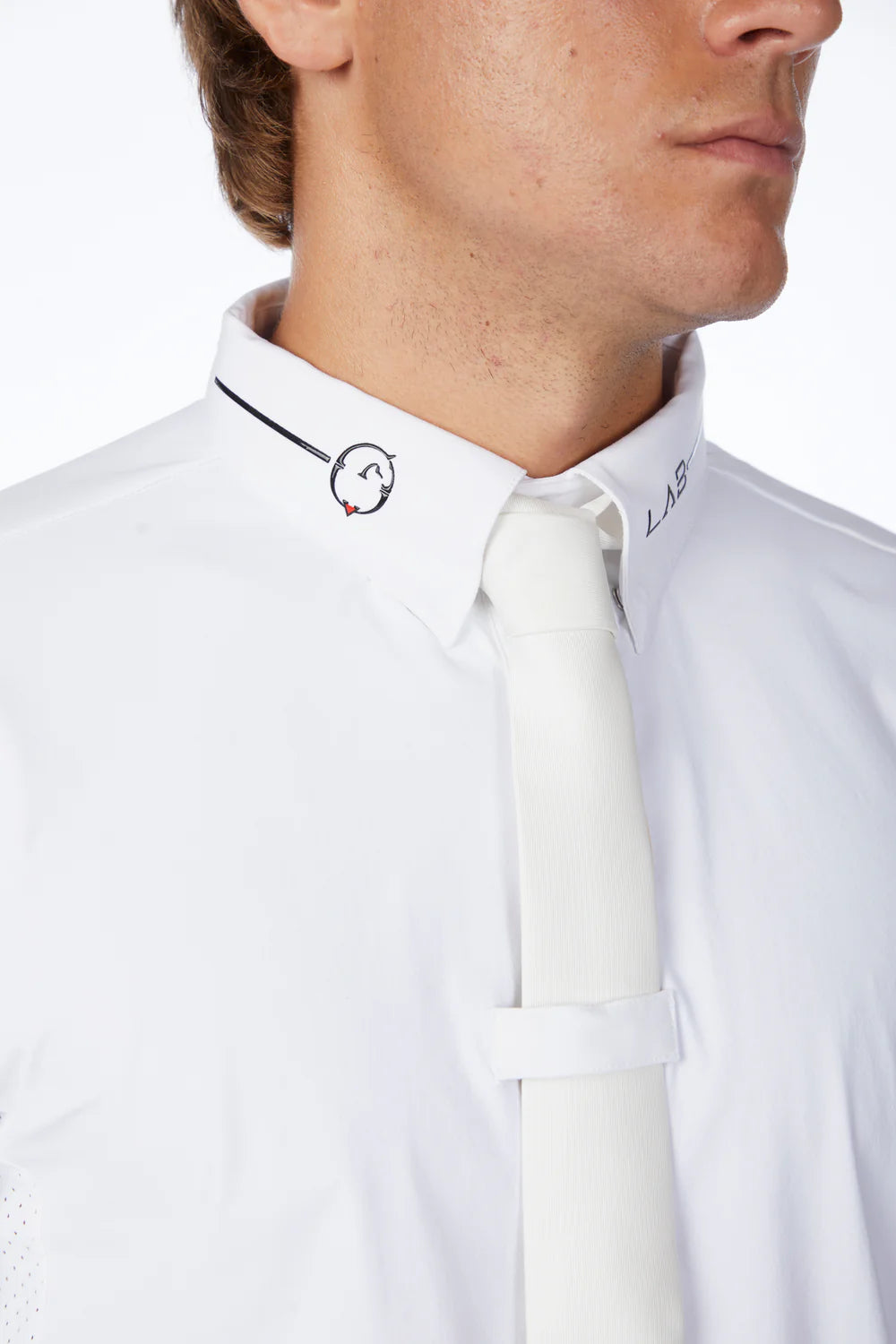 Close-up of a person wearing a white shirt with a visible brand logo.