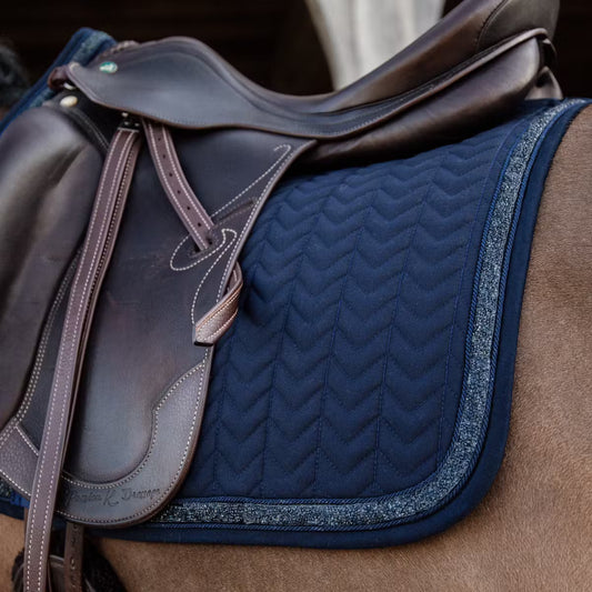 Glittery navy saddle pad under a brown saddle