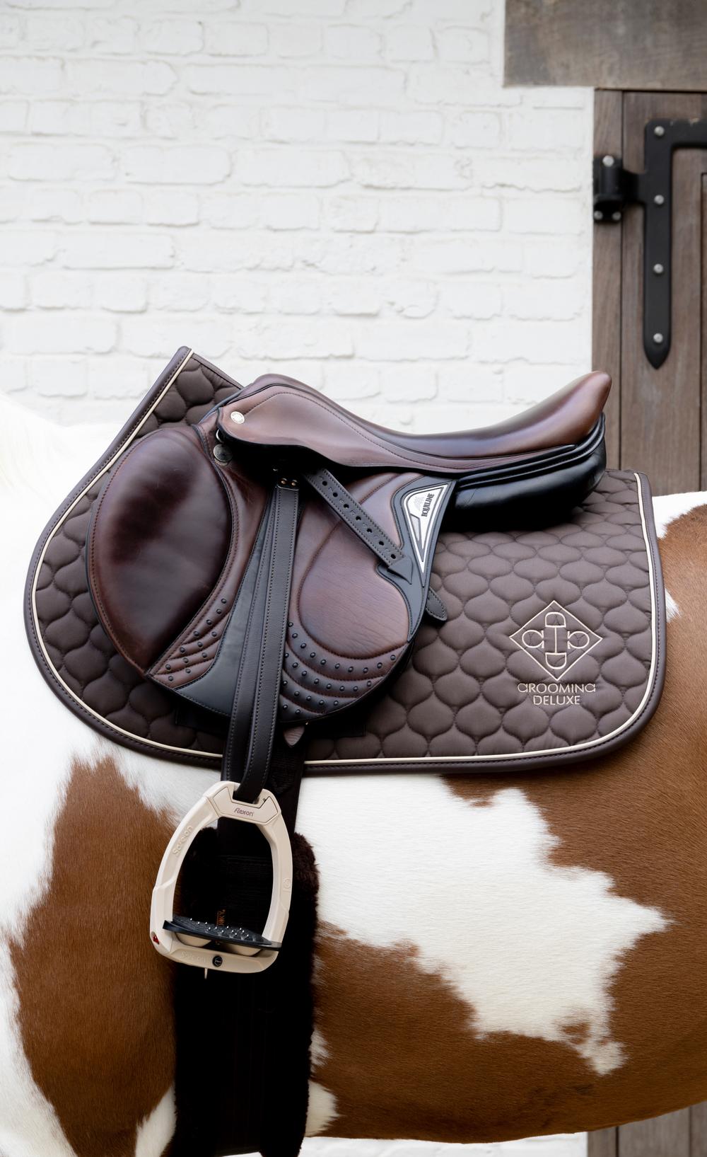 brown saddle with brown quilted pad beneath it