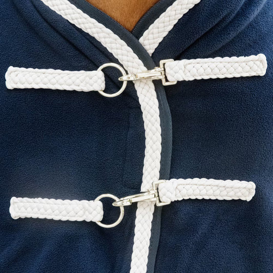 Navy blue horse rug front buckles with white corduroy on a horse