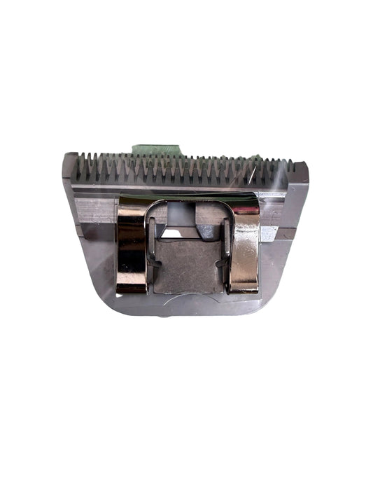 A metal electric clipper blade with a silver-colored guard, sealed inside a clear plastic protective sleeve, placed on a green and white polka dot surface.