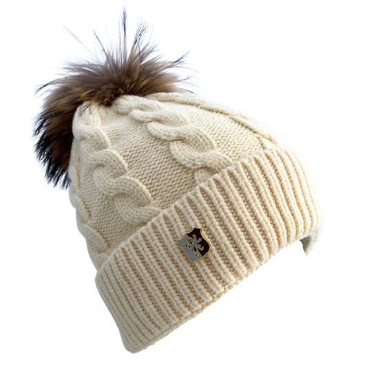 Beige knitted beanie with a fur pom-pom on a white background