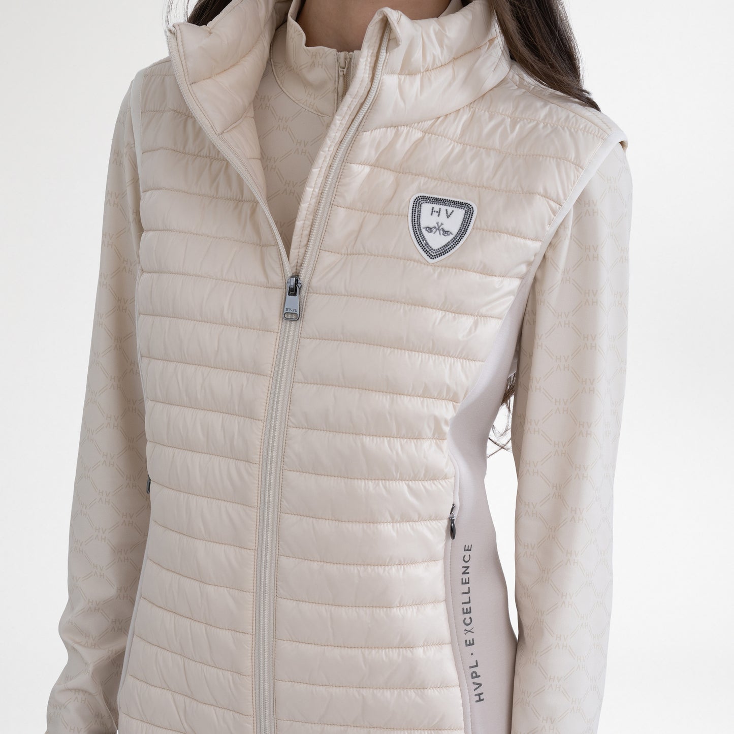 Girl wearing a cream gilet and baselayer on a white background
