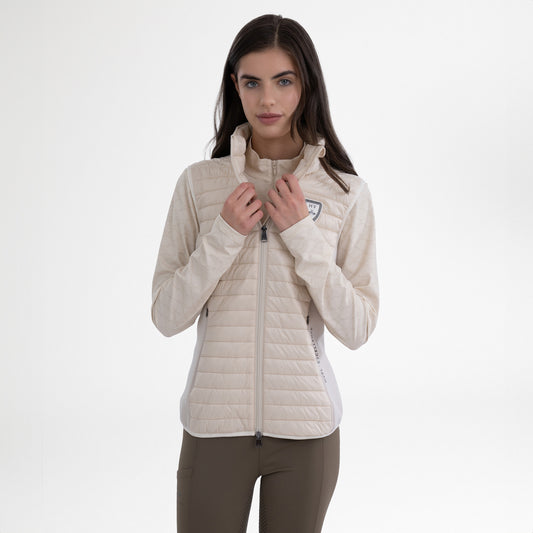 Girl wearing a cream gilet and brown breeches on a white background