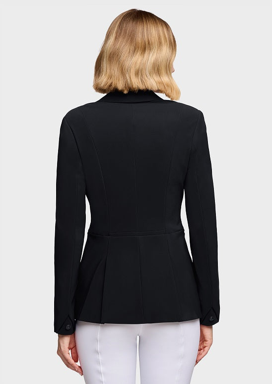A woman viewed from the back wearing a structured black blazer with long sleeves and a peplum-like waist, paired with white pants, against a light gray studio background.
