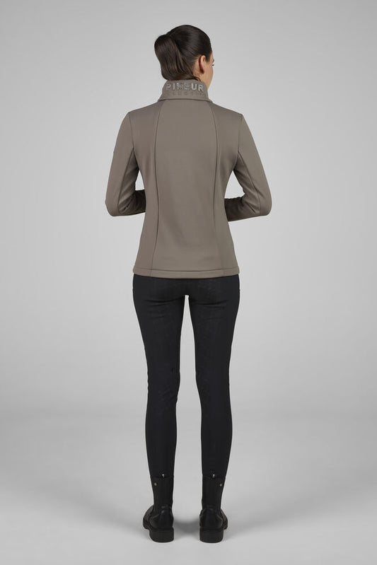 Person wearing a brown jacket and black pants on a gray background