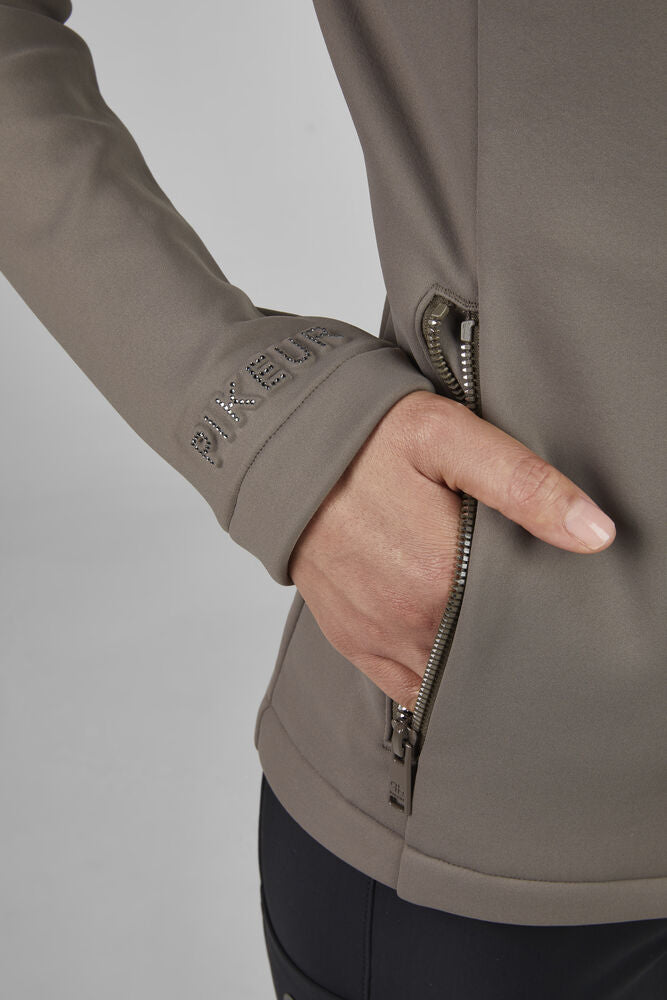 Close-up of a person wearing a brown jacket with a zipper, on a plain background.
