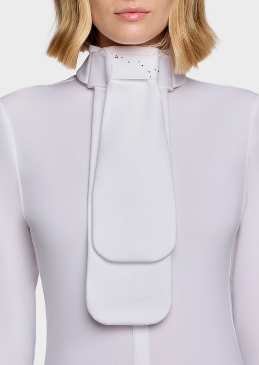 A close-up of a model wearing a light gray or off-white high-neck top with a large structured bow or pleated collar detail at the front.