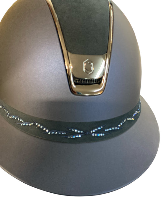 Navy riding helmet with decorative band on a white background