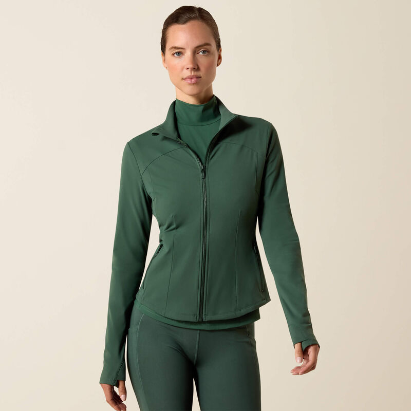 Woman wearing a green jacket and pants on a beige background