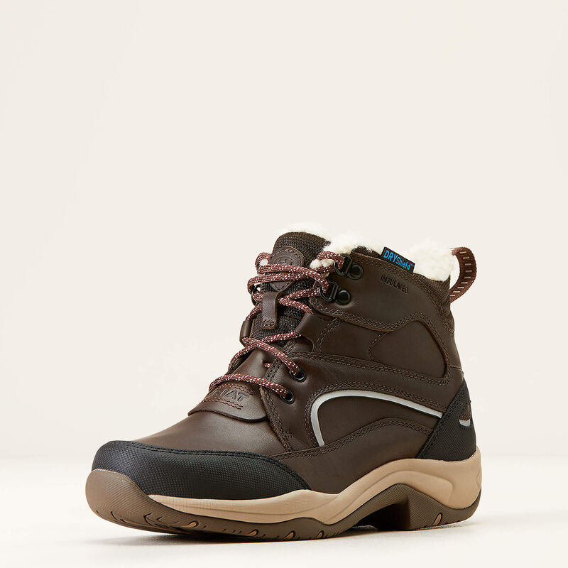 Brown hiking boot with white fur lining on a beige background