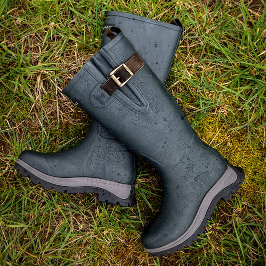 Pair of navy rubber boots with a buckle on grass
