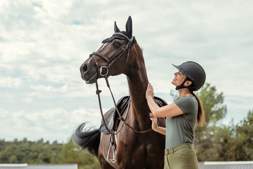 Girl holding a horse in an outdoor setting