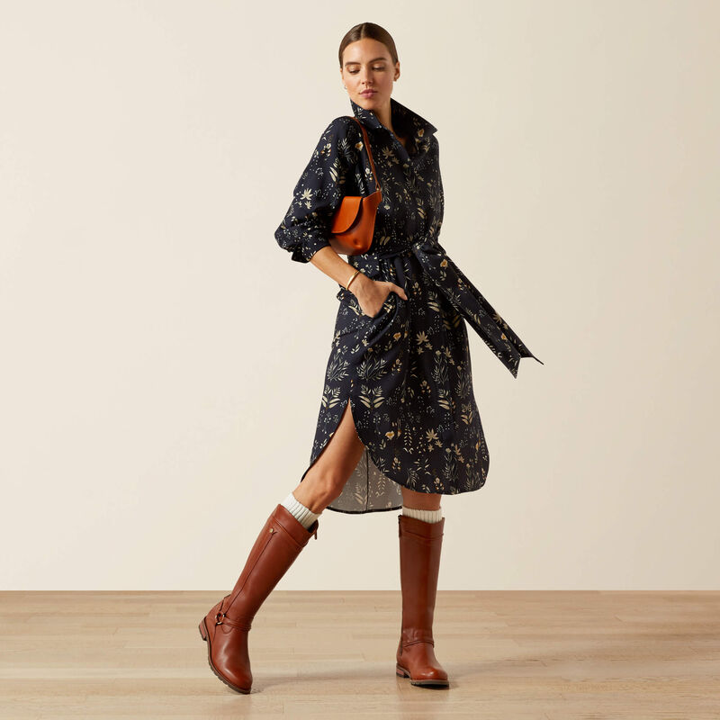 Woman wearing a navy floral shirt dress styled with tan leather knee boots and an orange shoulder bag – Ariat Autumn Winter 2025 fashion at Boomerang.ie
