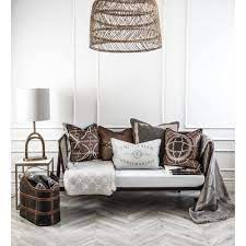 Image of cushions arranged on a white sofa with equestrian themed objects surrounding them