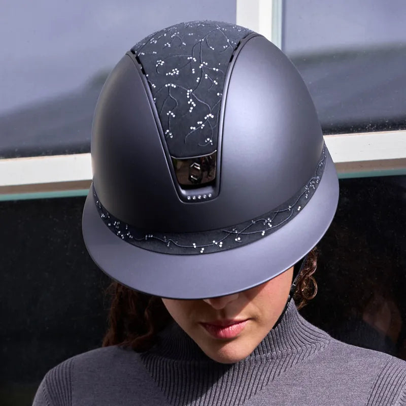 Woman wearing a navy Samshield riding helmet with crystal and floral detailing – luxury custom equestrian helmet from Boomerang.ie
