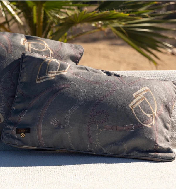 Two green cushions on a sunny bench outside with a palm tree visible
