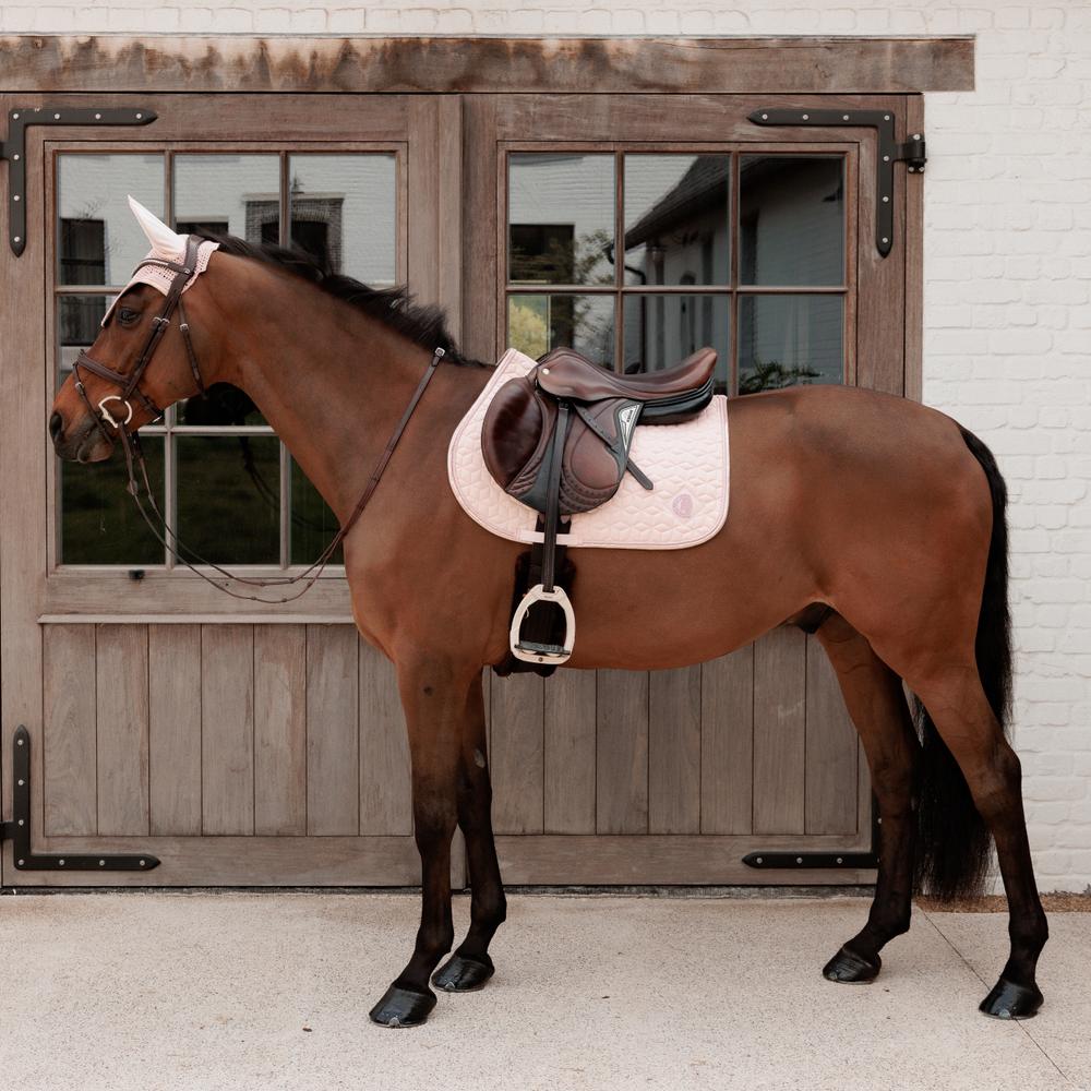 Pink saddlepad under a brown saddle on a bay horse