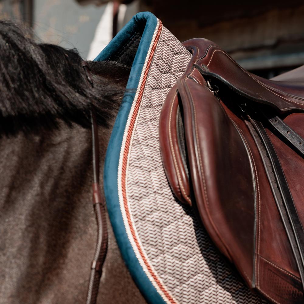 Saddle pad on a horse under a brown saddle