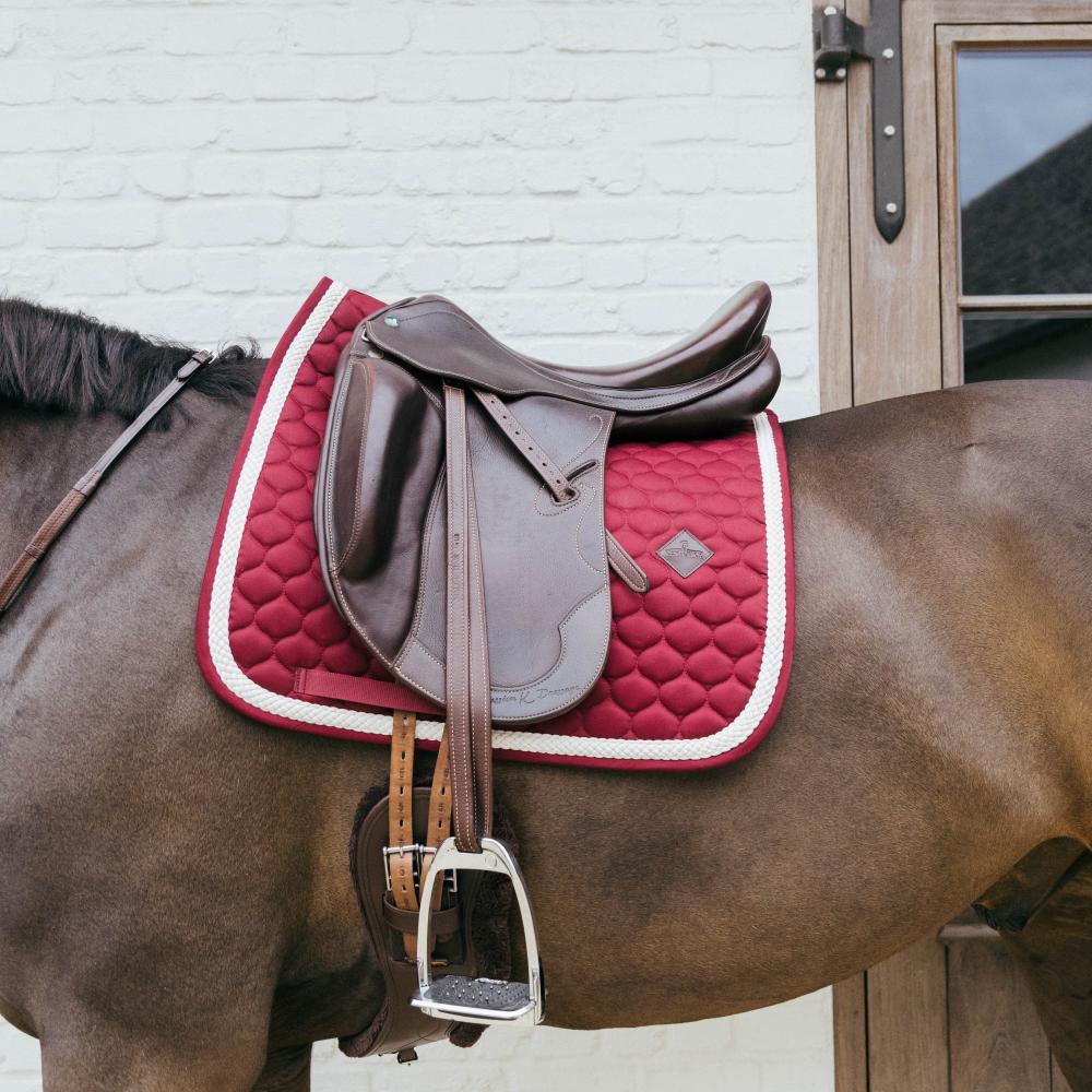 Bordeaux saddlepad under a brown saddle on a bay horse