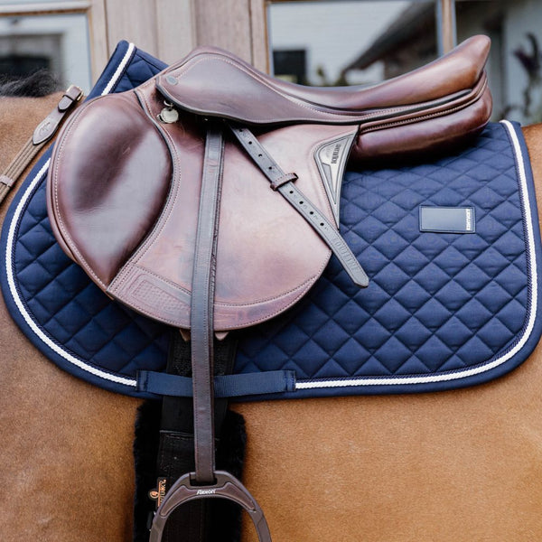 Saddle and blue quilted saddle pad on a horse