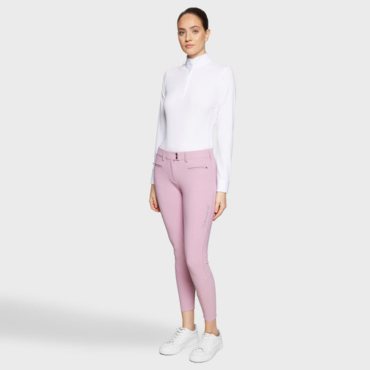 Woman wearing a white shirt and pink pants on a white background