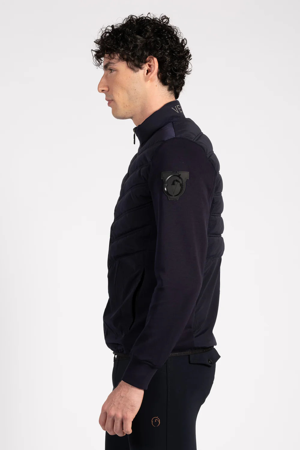 Man wearing a dark navy jacket with a brand logo on a white background