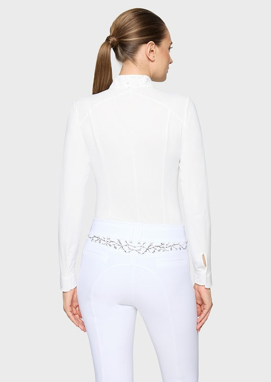 A woman shown from the back wearing a white long-sleeve mock-neck top and white fitted pants with a decorative embroidered waistband.
