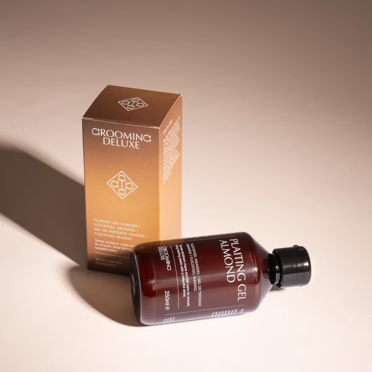 A bottle of grooming plating gel and its matching box, both in a warm brown gradient color, on a beige background with a soft shadow.