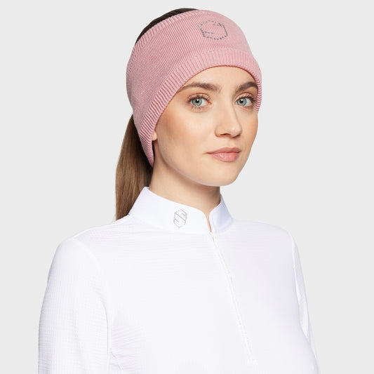 Woman wearing a pink headband with glitzy logo and a white shirt on a white background
