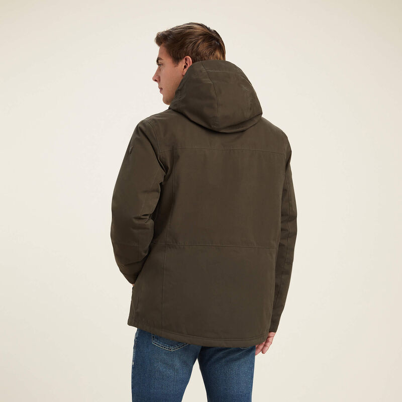 Person wearing a brown hooded jacket on a beige background