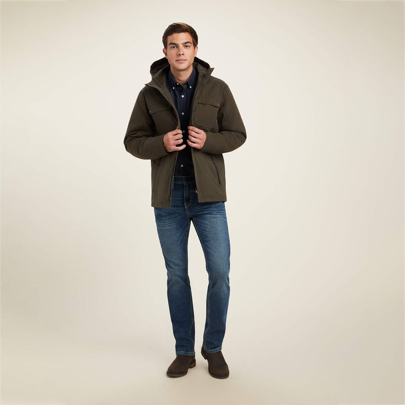 Man wearing a green jacket and blue jeans on a beige background