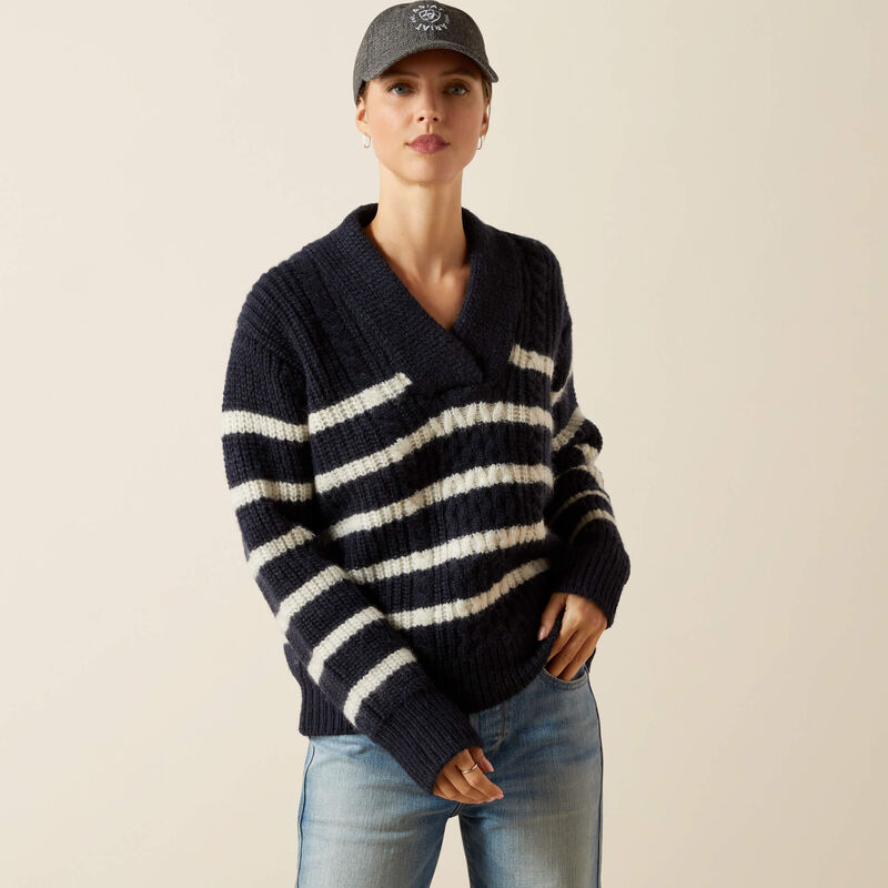 Person wearing a navy and white striped sweater with a plain background