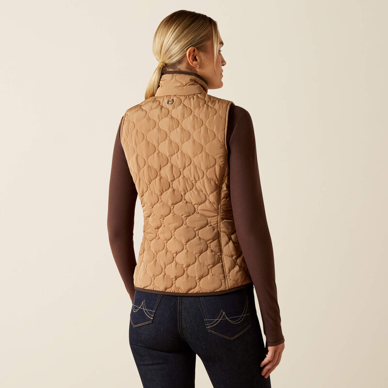 Person wearing a beige quilted vest on a beige background