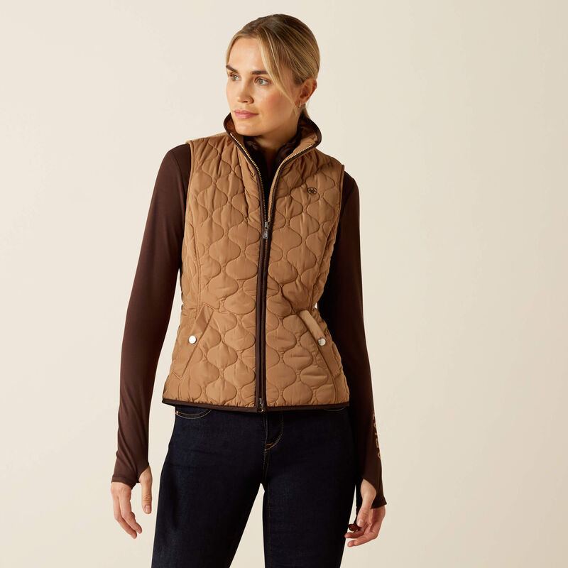 Person wearing a beige quilted vest on a beige background