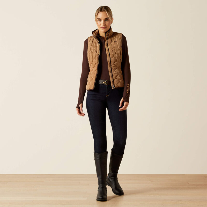 Person wearing a beige quilted vest on a beige background