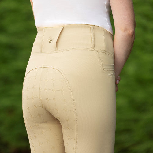 Beige riding pants worn by a person with a blurred green background