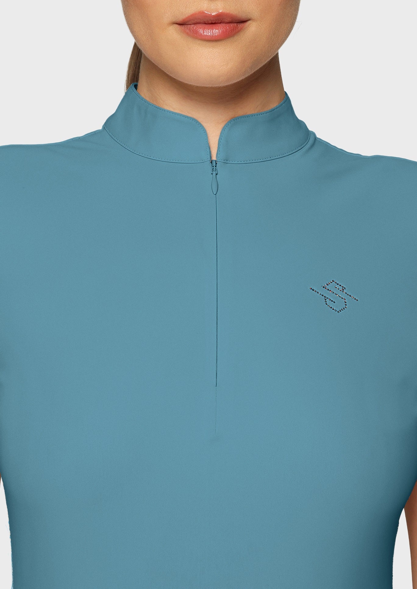 Close up of a woman wearing a blue shirt on a beige background