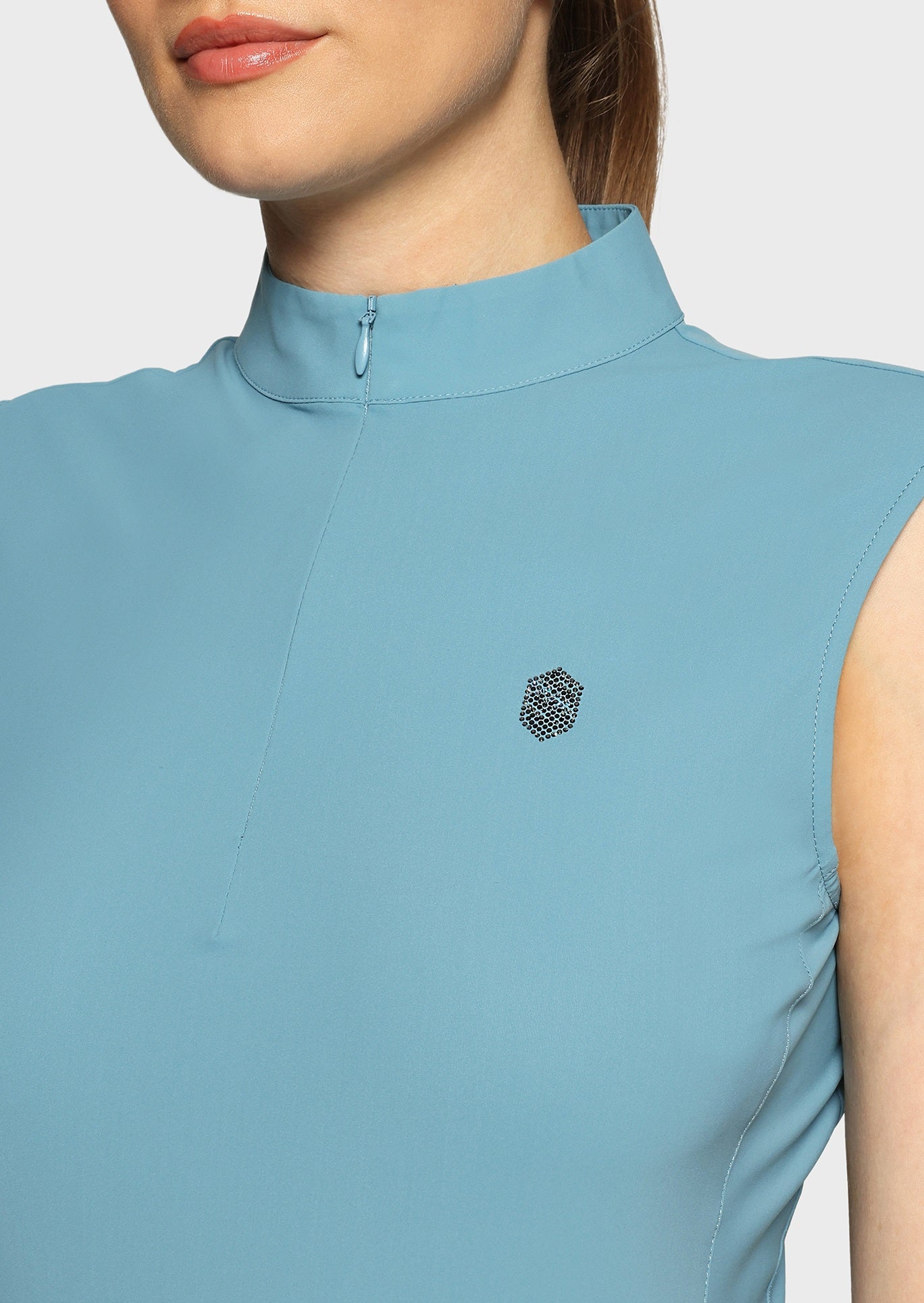 Woman wearing a blue sleeveless top on a beige background