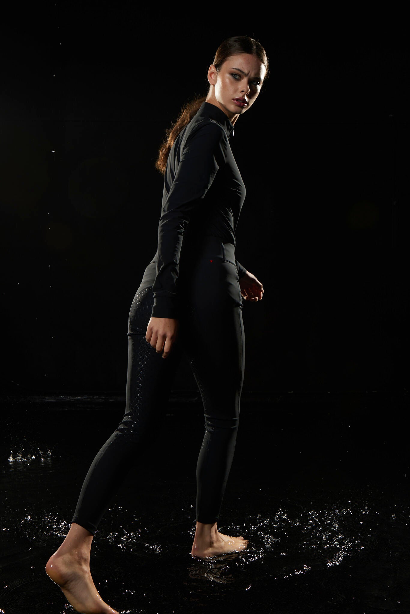 Person wearing a black wetsuit on a dark background