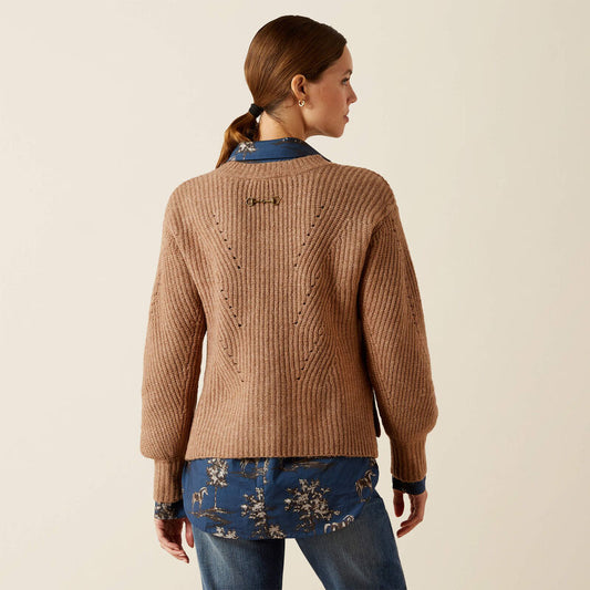 Woman wearing a brown knitted sweater and blue jeans on a beige background