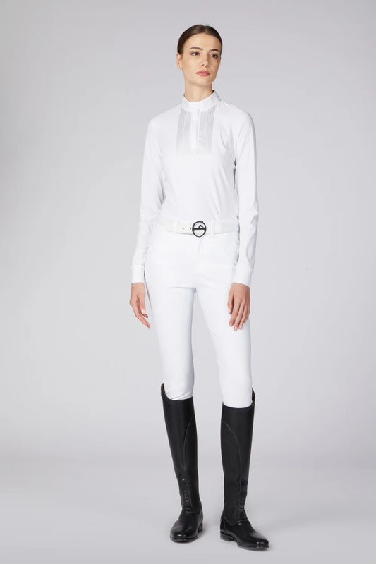 Woman wearing a white outfit and black long boots on a grey background
